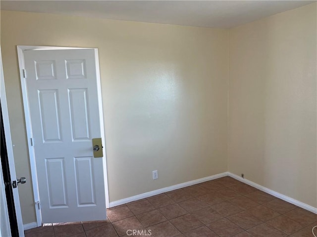 unfurnished room featuring dark tile patterned floors