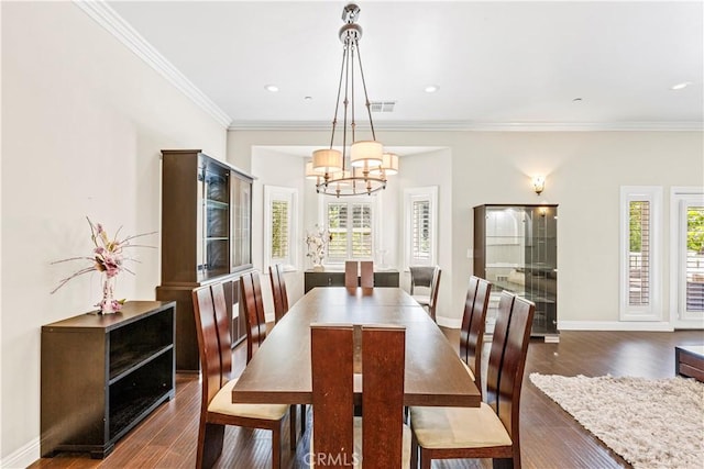 dining area with dark hardwood / wood-style flooring, a chandelier, and ornamental molding