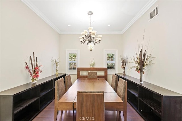 dining area featuring dark hardwood / wood-style flooring, an inviting chandelier, and ornamental molding