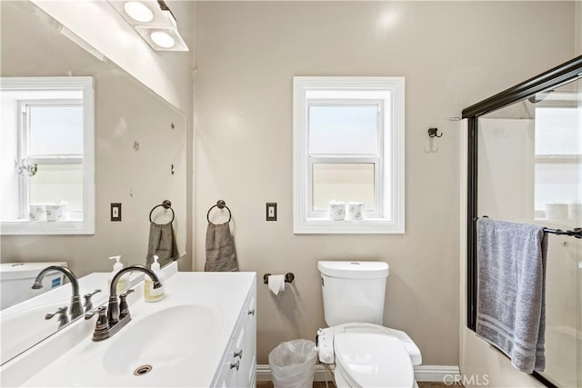 bathroom featuring plenty of natural light, vanity, and toilet