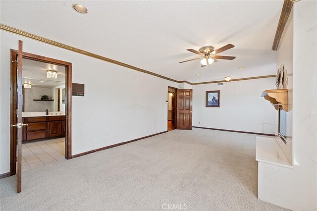 carpeted spare room featuring ceiling fan and ornamental molding