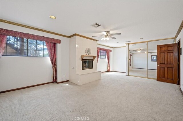 unfurnished living room with ceiling fan, carpet, and ornamental molding