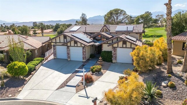 view of front of home featuring solar panels, a garage, and a mountain view