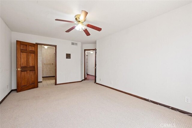 unfurnished bedroom featuring ceiling fan, light colored carpet, and connected bathroom