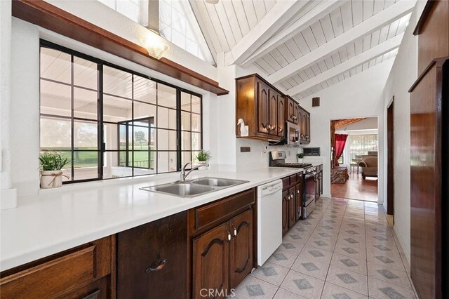 kitchen featuring dark brown cabinets, stainless steel appliances, sink, beamed ceiling, and light tile patterned flooring