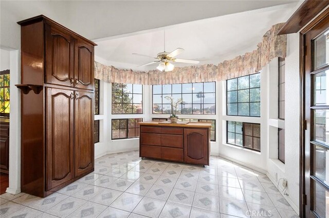 kitchen featuring dark brown cabinetry, ceiling fan, and light tile patterned floors