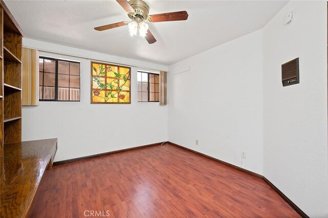 empty room featuring ceiling fan and dark hardwood / wood-style flooring