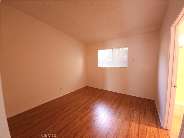 empty room with a textured ceiling and light wood-type flooring