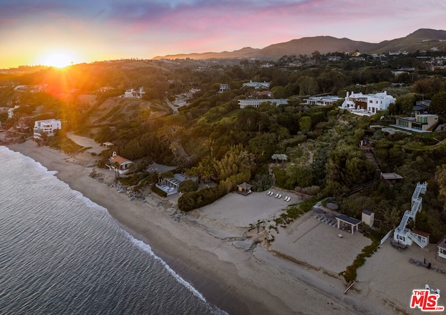 aerial view at dusk featuring a water and mountain view