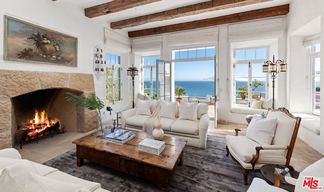 living room featuring a healthy amount of sunlight, beamed ceiling, and a water view