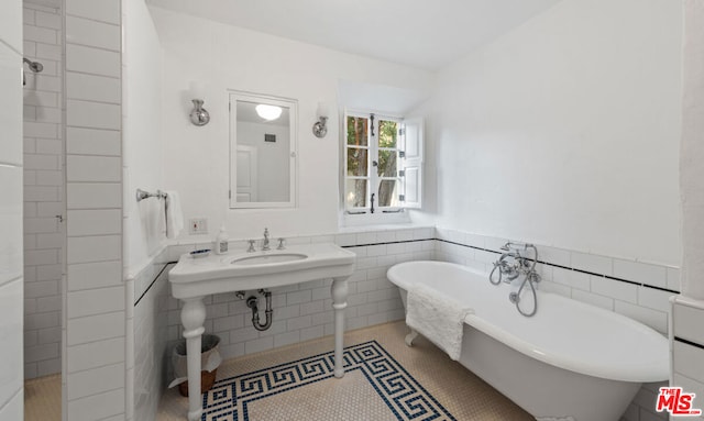 bathroom with a bathing tub and tile walls