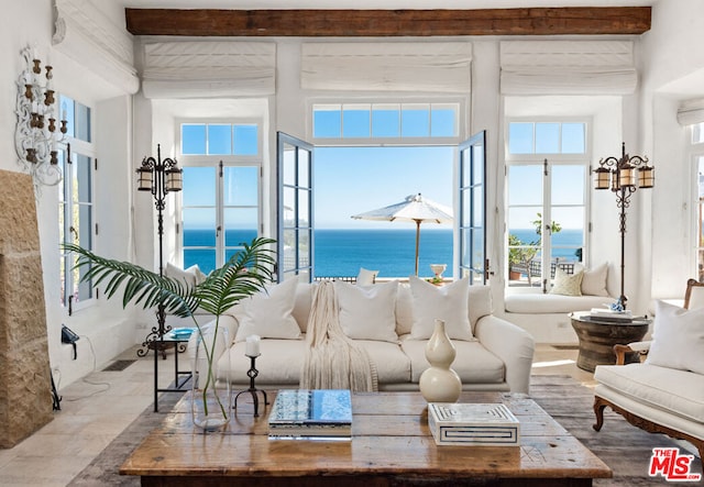 living room with a water view, plenty of natural light, and beam ceiling