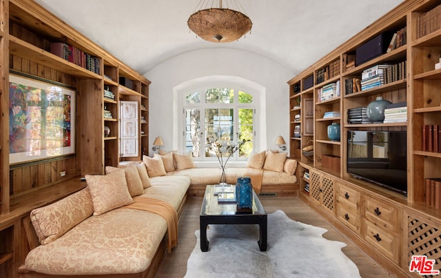 living area featuring wood-type flooring and vaulted ceiling