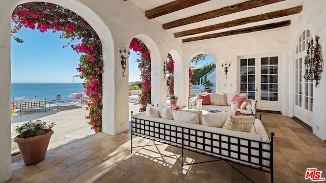 view of patio / terrace featuring a water view, an outdoor living space, and french doors