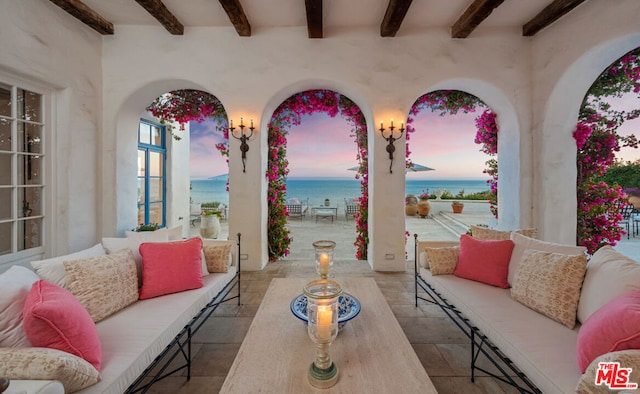 patio terrace at dusk with a water view and an outdoor living space