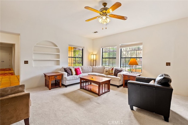 tiled living room with built in features and ceiling fan