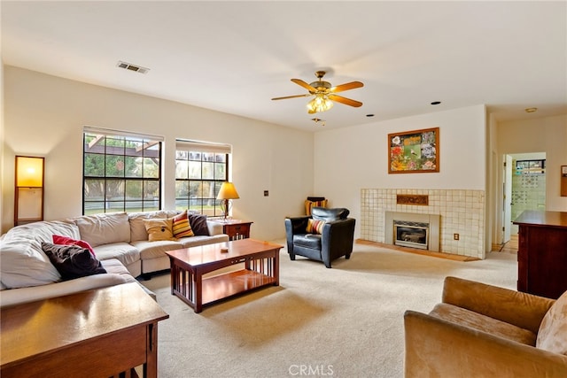 carpeted living room featuring ceiling fan and a fireplace