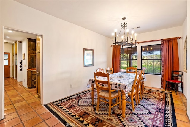 dining area with tile flooring and an inviting chandelier