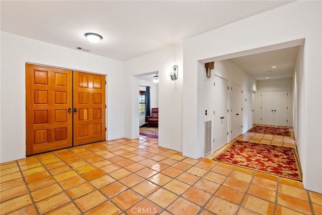 tiled foyer with ceiling fan