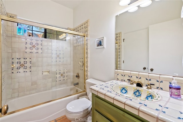 full bathroom featuring combined bath / shower with glass door, oversized vanity, and toilet