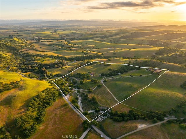 aerial view at dusk featuring a rural view