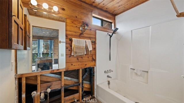 bathroom with shower / bathing tub combination, wood ceiling, and log walls