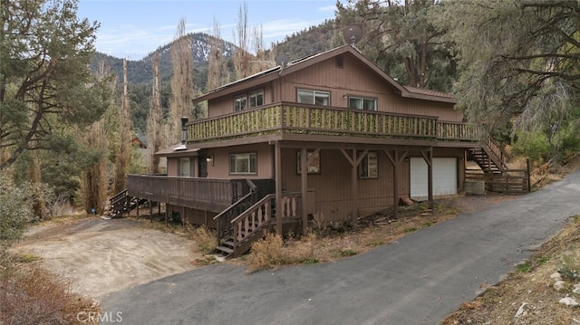 view of front of home featuring a garage and a deck with mountain view