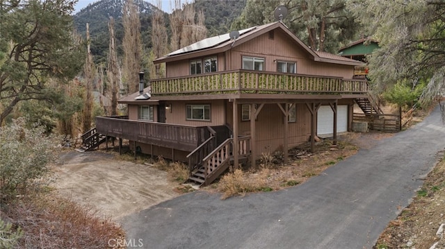 view of front facade with a wooden deck and a garage