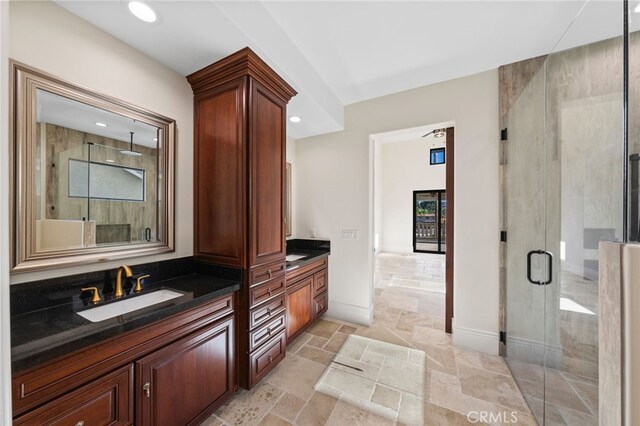 bathroom featuring double sink, a shower with shower door, tile floors, and large vanity