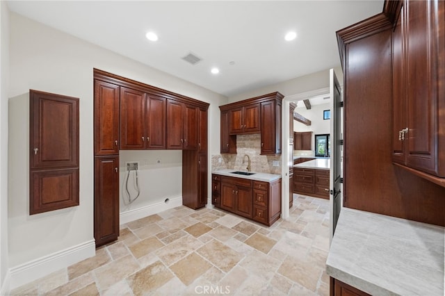 kitchen featuring sink, backsplash, and light tile flooring