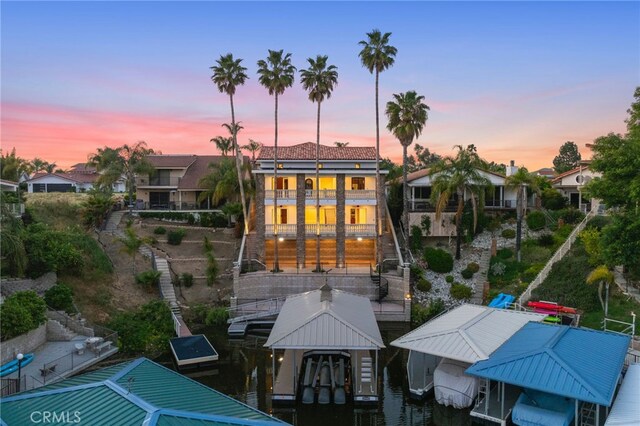 back house at dusk with a balcony