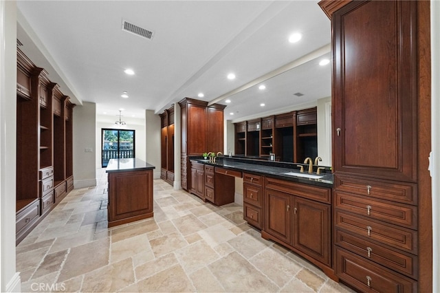 kitchen featuring sink, kitchen peninsula, light tile floors, and a kitchen island