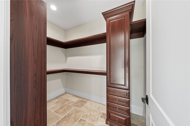 walk in closet featuring light tile floors