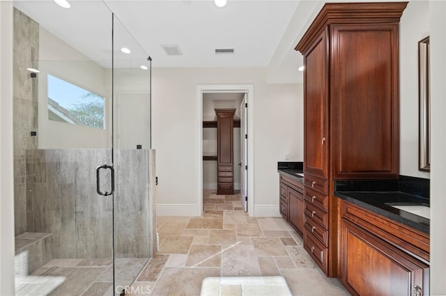 bathroom with walk in shower, tile flooring, and vanity