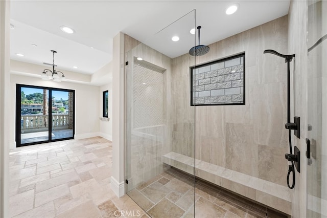 bathroom featuring tiled shower, tile flooring, and a notable chandelier