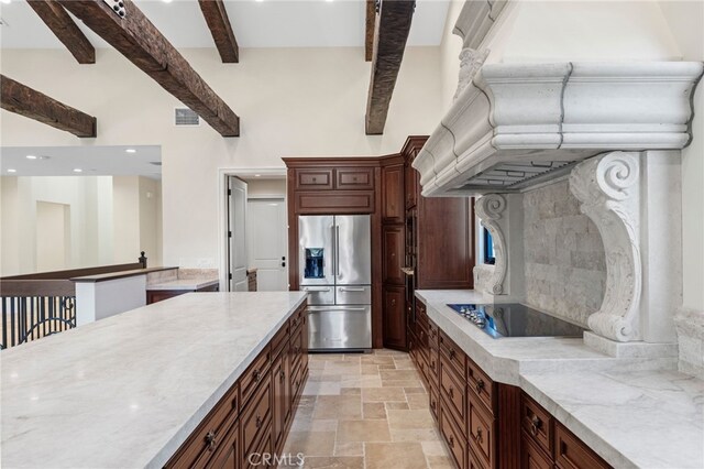 kitchen featuring black electric stovetop, light tile flooring, beam ceiling, light stone counters, and high quality fridge