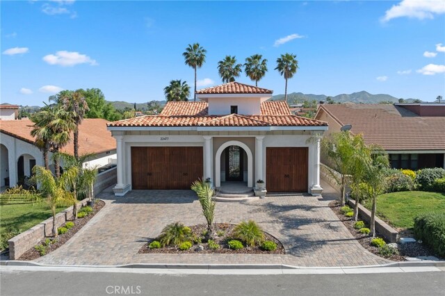 mediterranean / spanish-style house with a mountain view and a garage