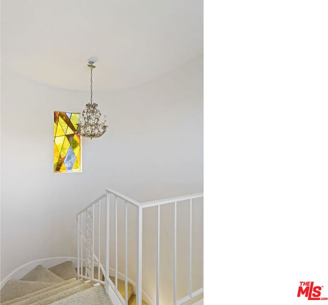 stairs featuring carpet and a notable chandelier