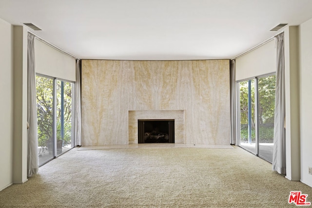 unfurnished living room featuring carpet and a wealth of natural light