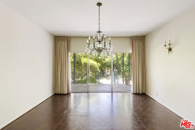 unfurnished dining area featuring plenty of natural light, dark hardwood / wood-style flooring, and a chandelier