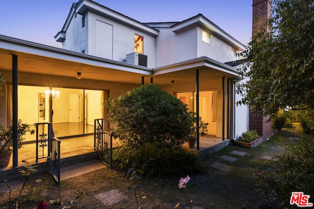 back house at dusk with a patio area