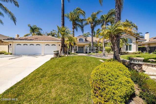 mediterranean / spanish home featuring a front yard and a garage