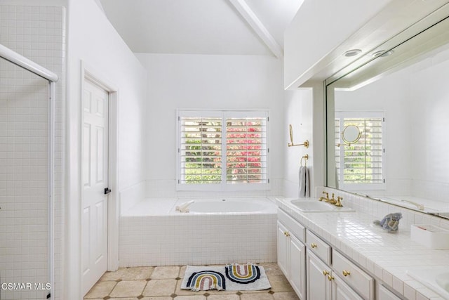 bathroom featuring tile patterned flooring, vanity, and tiled tub