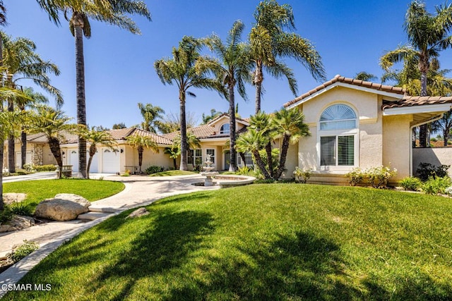 mediterranean / spanish-style home with a front lawn and a garage