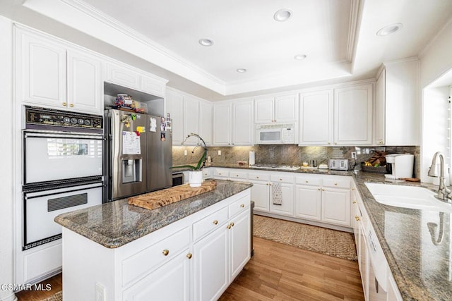 kitchen featuring white cabinetry, sink, appliances with stainless steel finishes, and dark stone counters