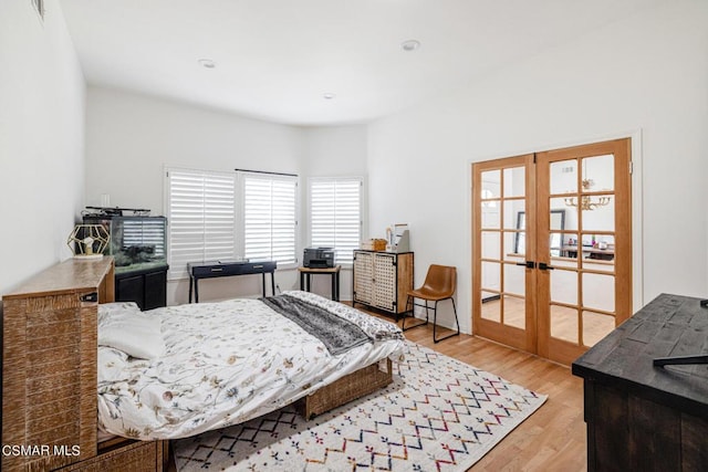 bedroom with french doors and light hardwood / wood-style flooring