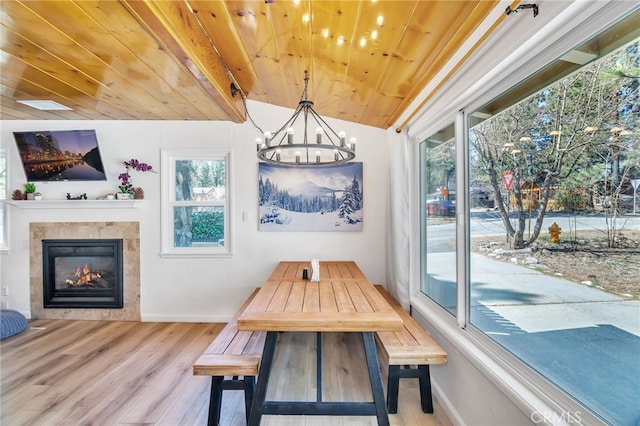 dining space featuring a notable chandelier, light hardwood / wood-style flooring, wooden ceiling, and a wealth of natural light