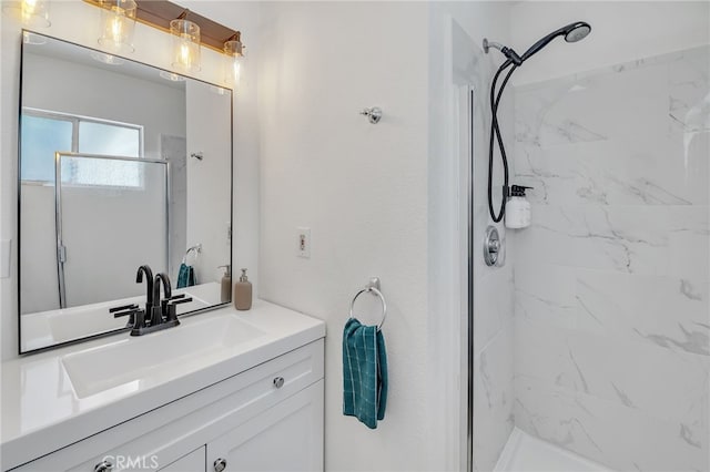 bathroom featuring a tile shower and vanity