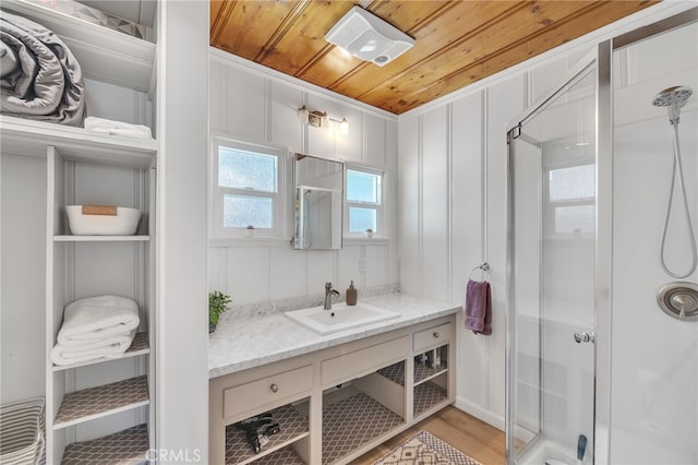 bathroom with vanity, hardwood / wood-style flooring, a shower with door, and wooden ceiling