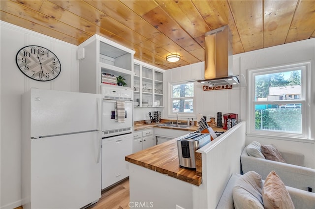 kitchen with island exhaust hood, white appliances, a wealth of natural light, and white cabinets